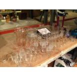 A LARGE AMOUNT OF GLASSWARE TO INCLUDE, JUGS, VASES, SHOT GLASSES, SHERRY, PORT, ETC