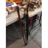 TWO WOODEN WALKING CANES, ONE WITH A SILVER COLOURED METAL TOP, THE OTHER BRASS HANDLED WITH