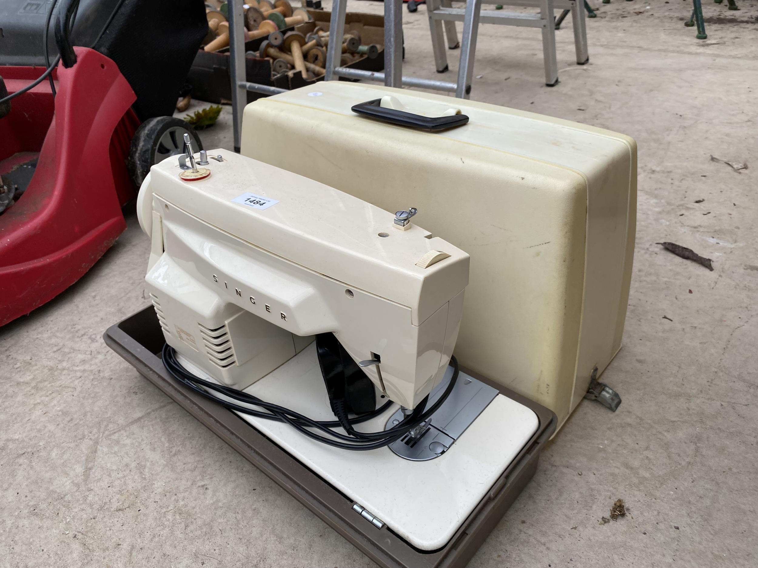A RETRO ELECTRIC SINGER SEWING MACHINE WITH FOOT PEDAL AND CARRY CASE