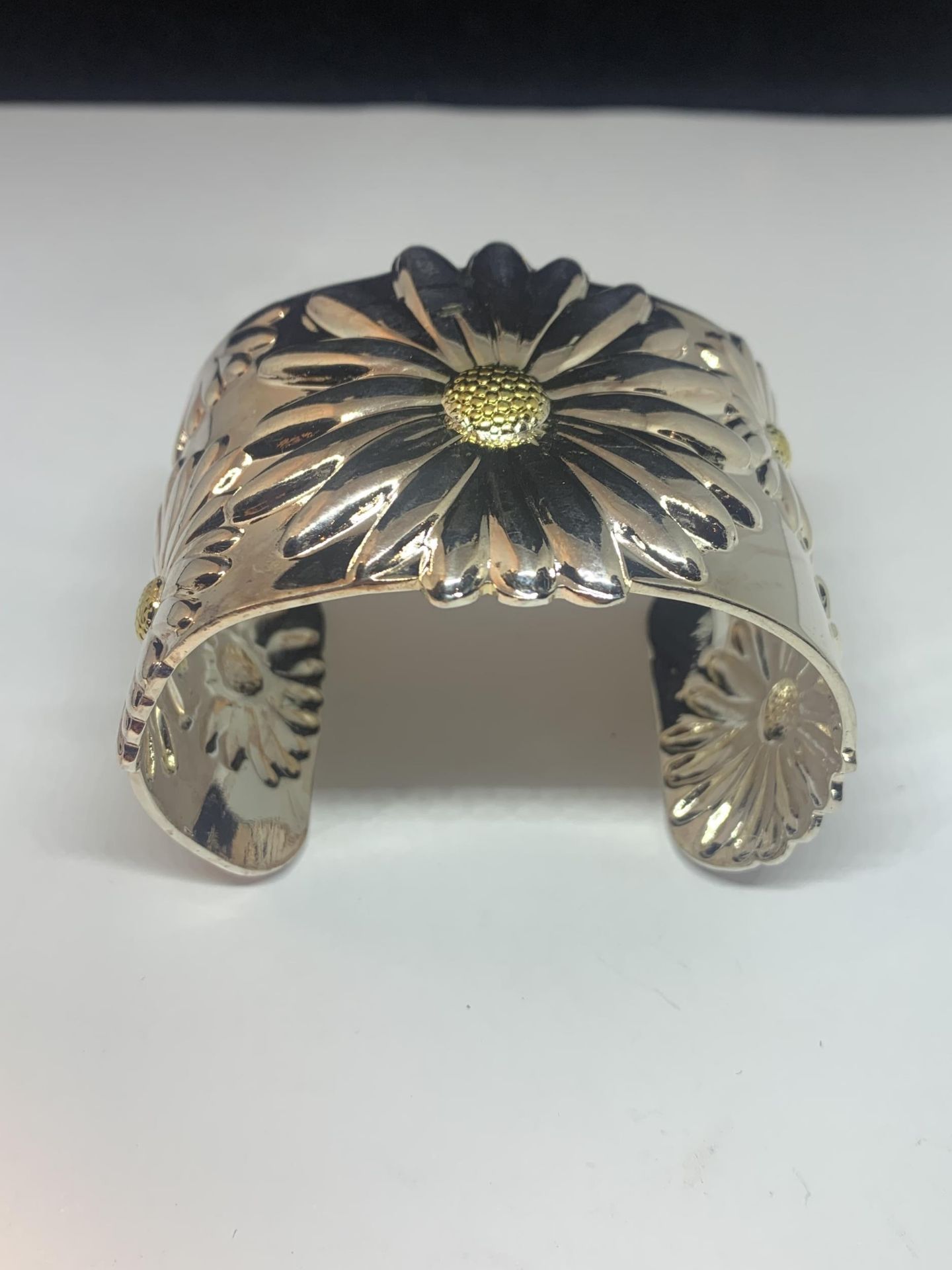 A MARKED 925 HEAVY BANGLE WITH SUNFLOWER DESIGN