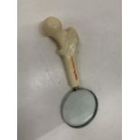 A CALCICHEW MAGNIFYING GLASS WITH A HIP BONE SHAPED HANDLE
