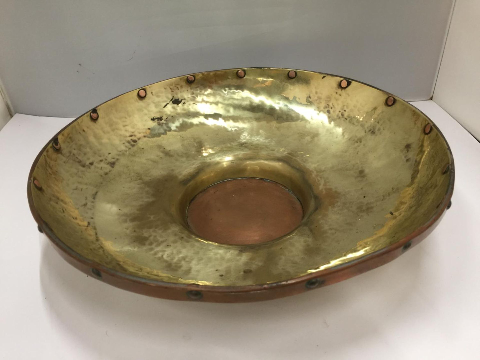 A LARGE BRASS BOWL WITH COPPER RIM AND BASE 35CM DIAMETER