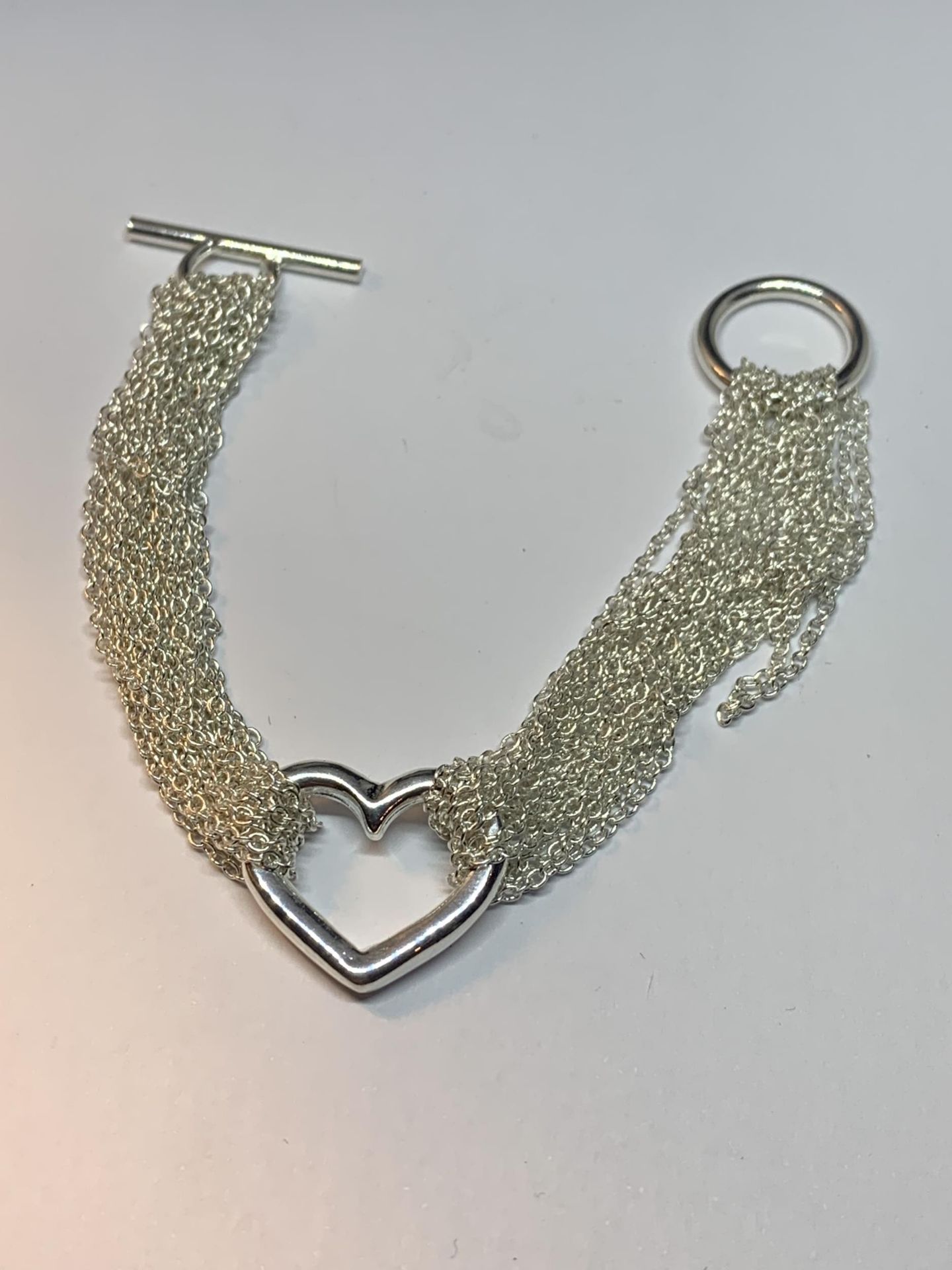 A SILVER HEART BRACELET IN A PRESENTATION BOX