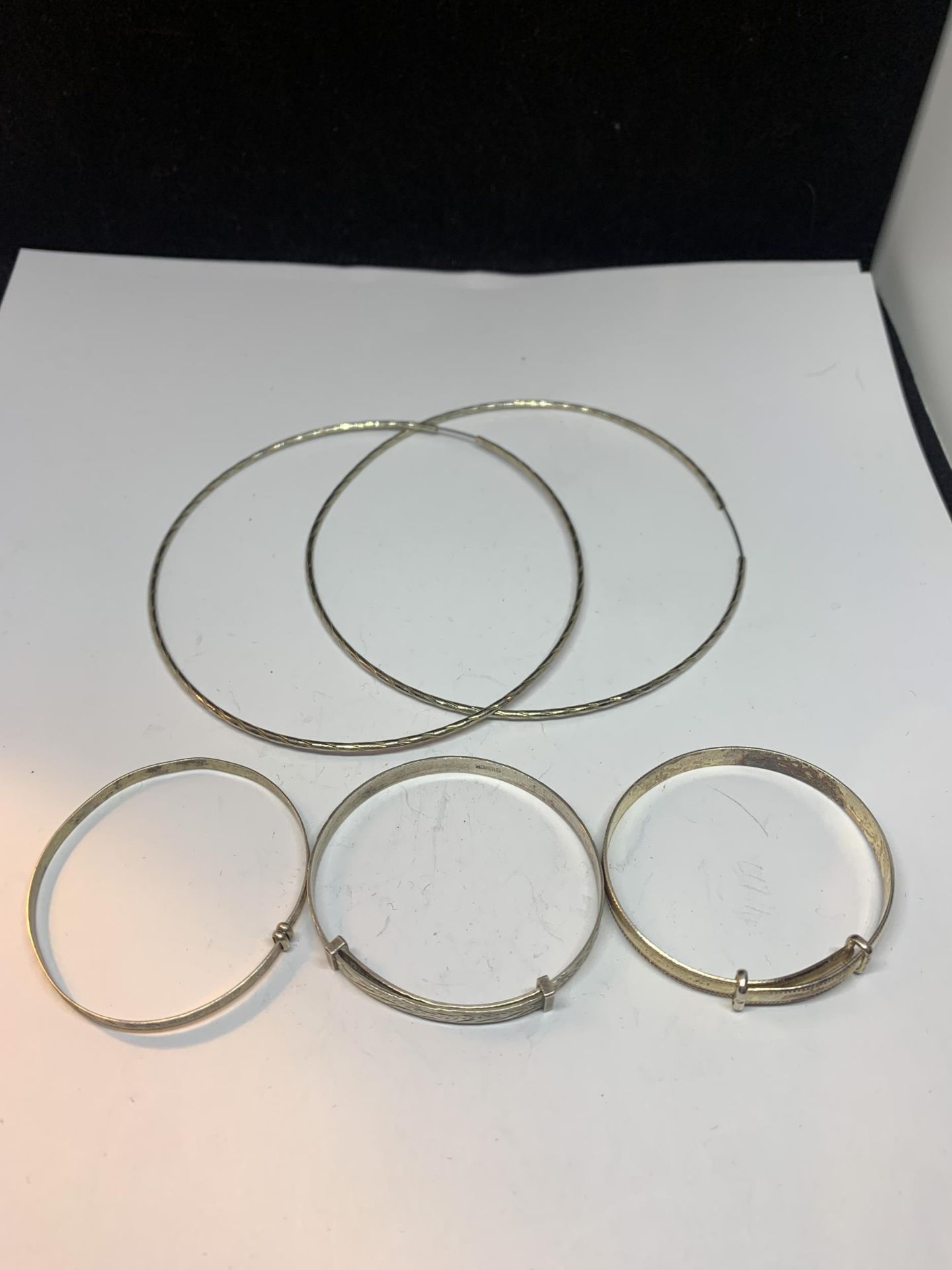 THREE SILVER CHILDRENS BANGLES AND A PAIR OF LARGE EARRINGS