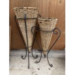 A PAIR OF WROUGHT IRON PLANT STANDS WITH WICKER INSERTS