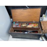A VINTAGE WOODEN TOOL CHEST CONTAINING VARIOUS TOOLS TO INCLUDE CHISELS, TIN SNIPS AND SPANNERS ETC