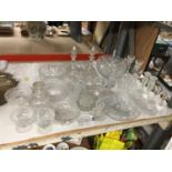 A LARGE QUANTITY OF GLASSWARE TO INCLUDE CUT GLASS DECANTERS, BOWLS, CANDLESTICKS, ETC