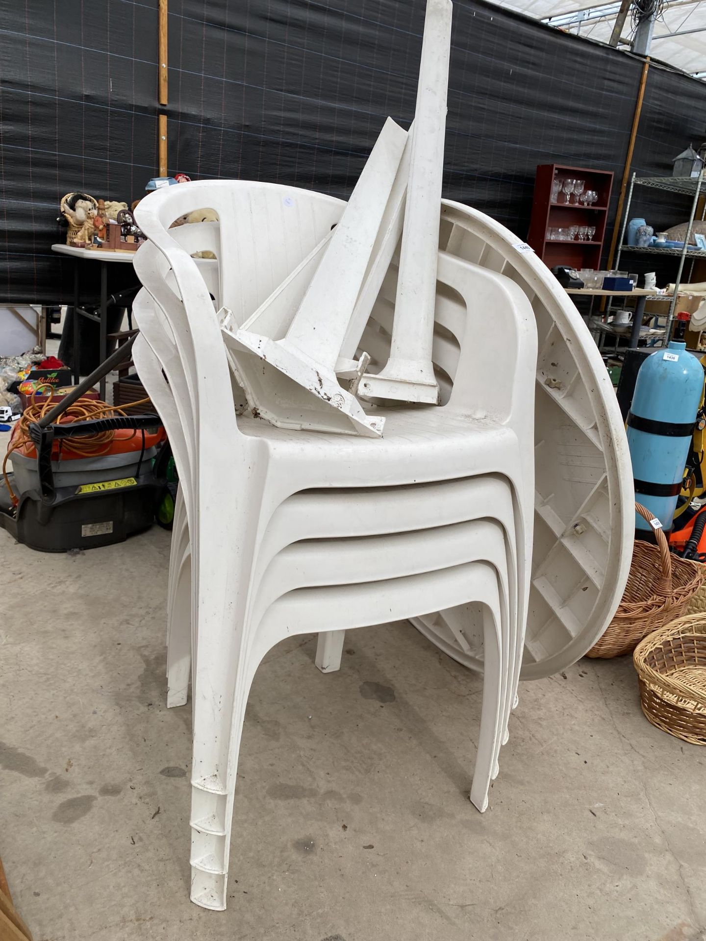 A WHITE PLASTIC GARDEN FURNITURE SET TO INCLUDE A ROUND TABLE AND FOUR STACKING CHAIRS