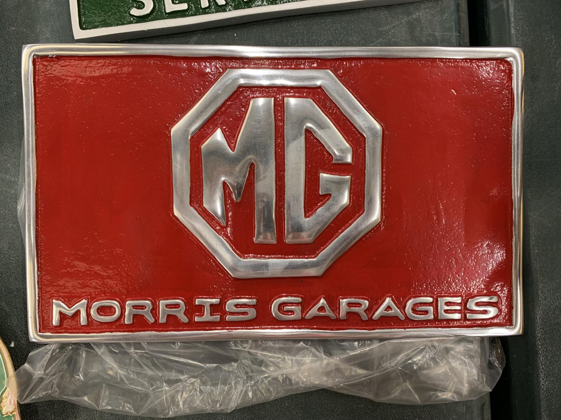 A CHROME AND RED MG MORRIS GARAGES SIGN 29CM X 17CM
