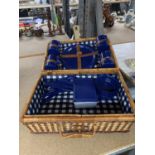 A WICKER PICNIC HAMPER WITH CUPS, PLATES ETC