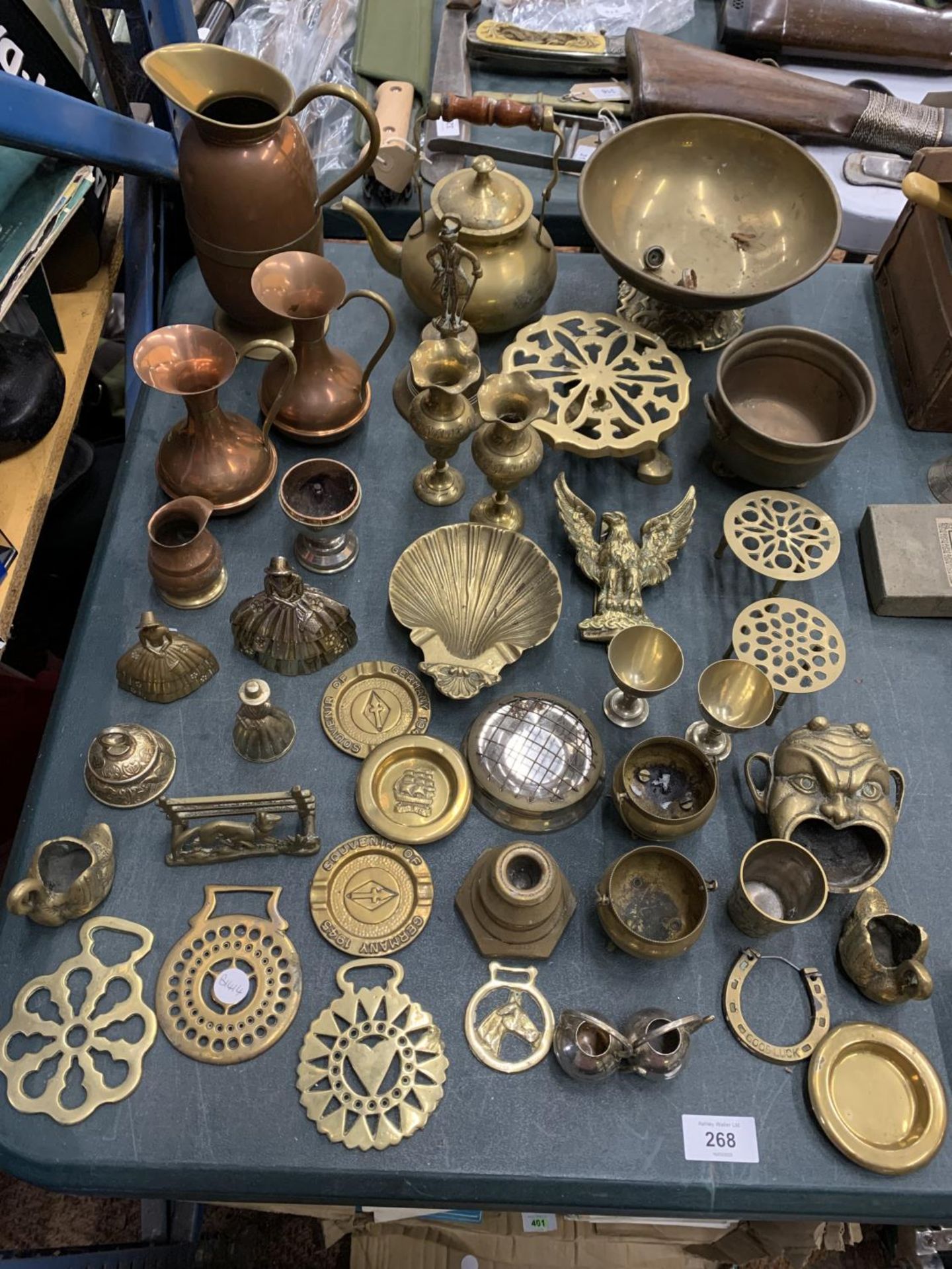 A LARGE COLLECTION OF BRASS AND COPPER WARE TO INCLUDE TRIVETS, BELLS, BOWLS, HORSE BRASSES ETC.