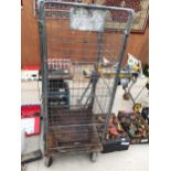 A LARGE METAL FOUR WHEELED STORAGE CAGE