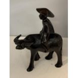 A CARVED HARDWOOD FIGURE OF A MAN RIDING A WATER BUFFALO