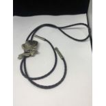 A SHOESTRING TIE WITH WHITE METAL COWBOY BOOT DECORATION