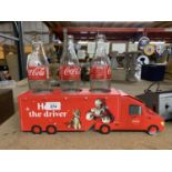 A COLLECTABLE LIGHT UP CHRISTMAS CARDBOARD COCA-COLA LORRY WITH THREE EMPTY COCA-COLA GLASS BOTTLES