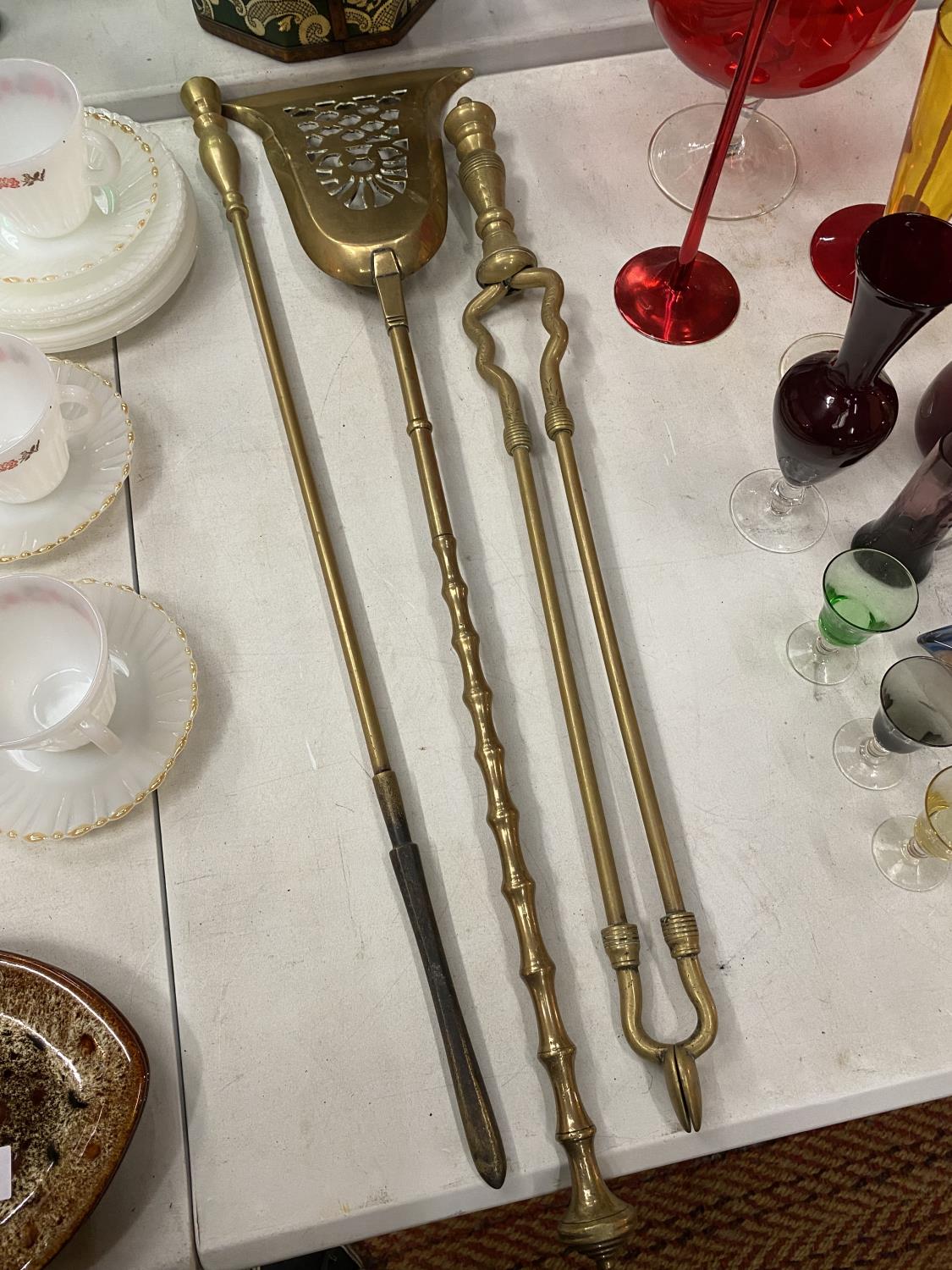 A SET OF BRASS FIRESIDE ITEMS TO INCLUDE, A POKER, TONGS AND A SHOVEL, SIZE 74CM