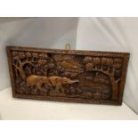 A HEAVILY CARVED OAK WALL HANGING WITH A SCENE OF ASIAN ELEPHANTS IN A FOREST SETTING