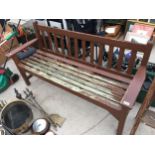 A WOODEN SLATTED GARDEN BENCH