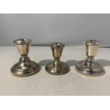 THREE HALLMARKED CANDLESTICKS TO INCLUDE A PAIR OF HALLMARKED BIRMINGHAM CANDLESTICKS AND A