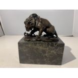 A BRONZE LION WITH A SNAKE ON A MARBLE BASE