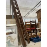 A VINTAGE WOODEN 16 RUNG EXTENDABLE LADDER AND A LONG REACH LOPPER