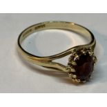 A 9 CARAT GOLD RING WITH A CENTRE RUBY SIZE O