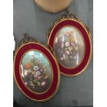 TWO GILT FRAMED OVAL PLAQUES WITH FLOWER DECORATIONS