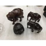 A FAMILY OF THREE CARVED WOODEN ELEPHANTS AND A WOODEN CARVED PIGS HEAD
