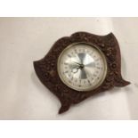 A WOODEN WESTCLOX MANTLE CLOCK WITH A FLORAL CARVED FRONT