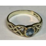 A 9 CARAT GOLD RING WITH AN AQUAMARINE STONE AND CROSS DECORATION TO SHOULDERS SIZE L