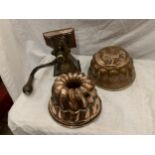 A VINTAGE WALL MOUNTED COFFEE GRINDER AND TWO VINTAGE COPPER JELLY MOULDS, ONE WITH HENS DECORATION
