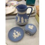 FOUR PIECES OF BLUE WEDGWOOD JASPERWARE TO INCLUDE, A JUG, TRINKET BOX AND TWO PIN TRAYS