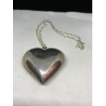 A NECKLACE WITH A LARGE SILVER HEART PENDANT