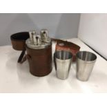THREE HIP FLASKS IN A LEATHER CARRYING CASE AND A SET OF FOUR STAINLESS STEEL BEAKERS IN A LEATHER
