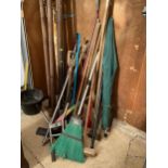 A LARGE ASSORTMENT OF GARDEN TOOLS TO INCLUDE SPADES, RAKES AND HOES ETC