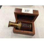 A SMALL BRASS AND LEATHER TELESCOPE IN A WOODEN BOX SIZE WHEN OPENED 8.5 CM