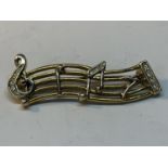 A YELLOW METAL POSSIBLY GOLD BROOCH WITH A MUSICAL THEME IN A PRESENTATION BOX