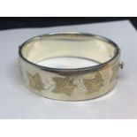 A HALLMARKED BIRMINGHAM SILVER BANGLE WITH GILDED IVY DESIGN IN A PRESENTATION BOX GROSS WEIGHT 58.8