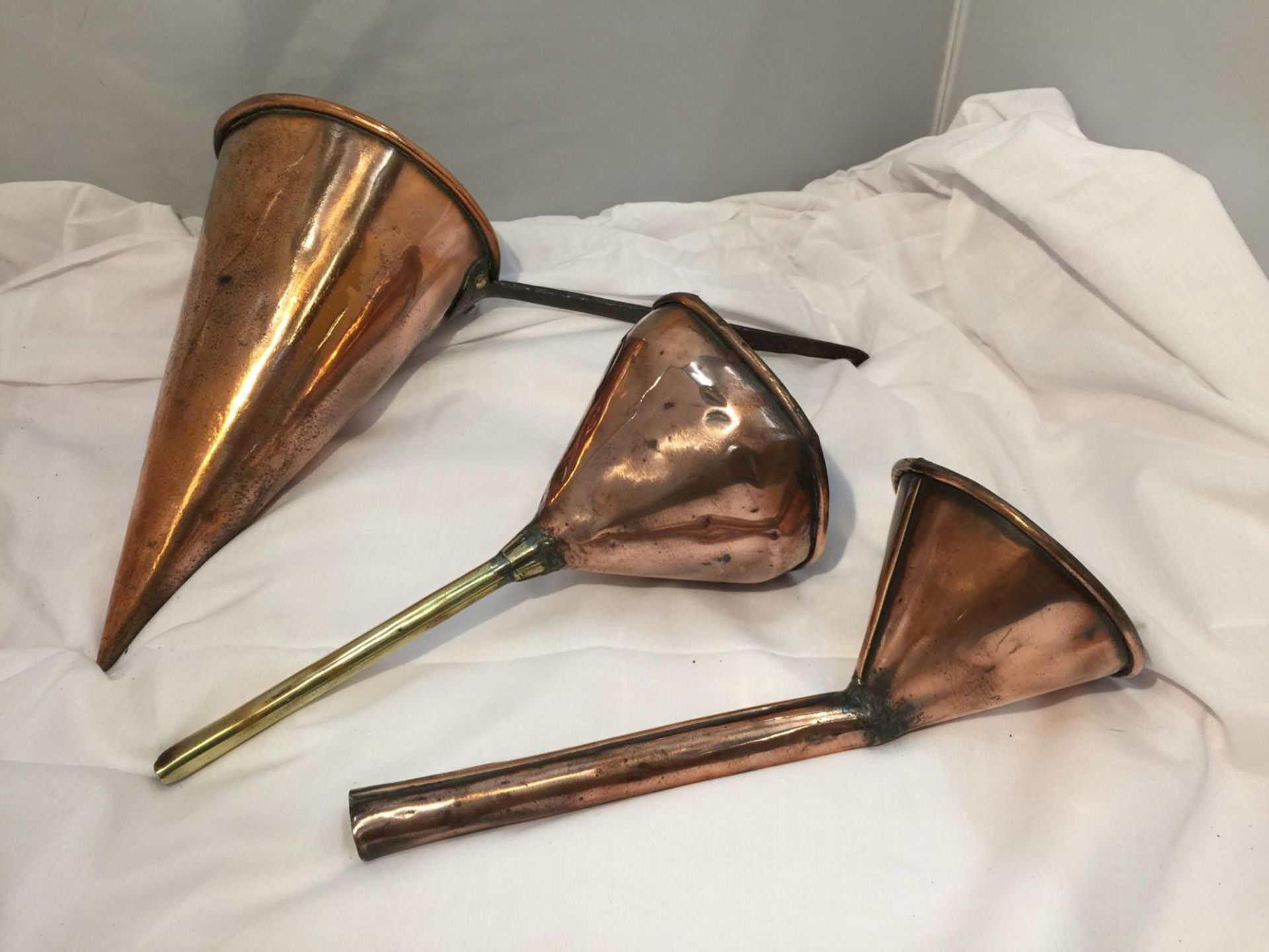 AN ANTIQUE COPPER ALE MULLER WITH TWO COPPER FUNNELS