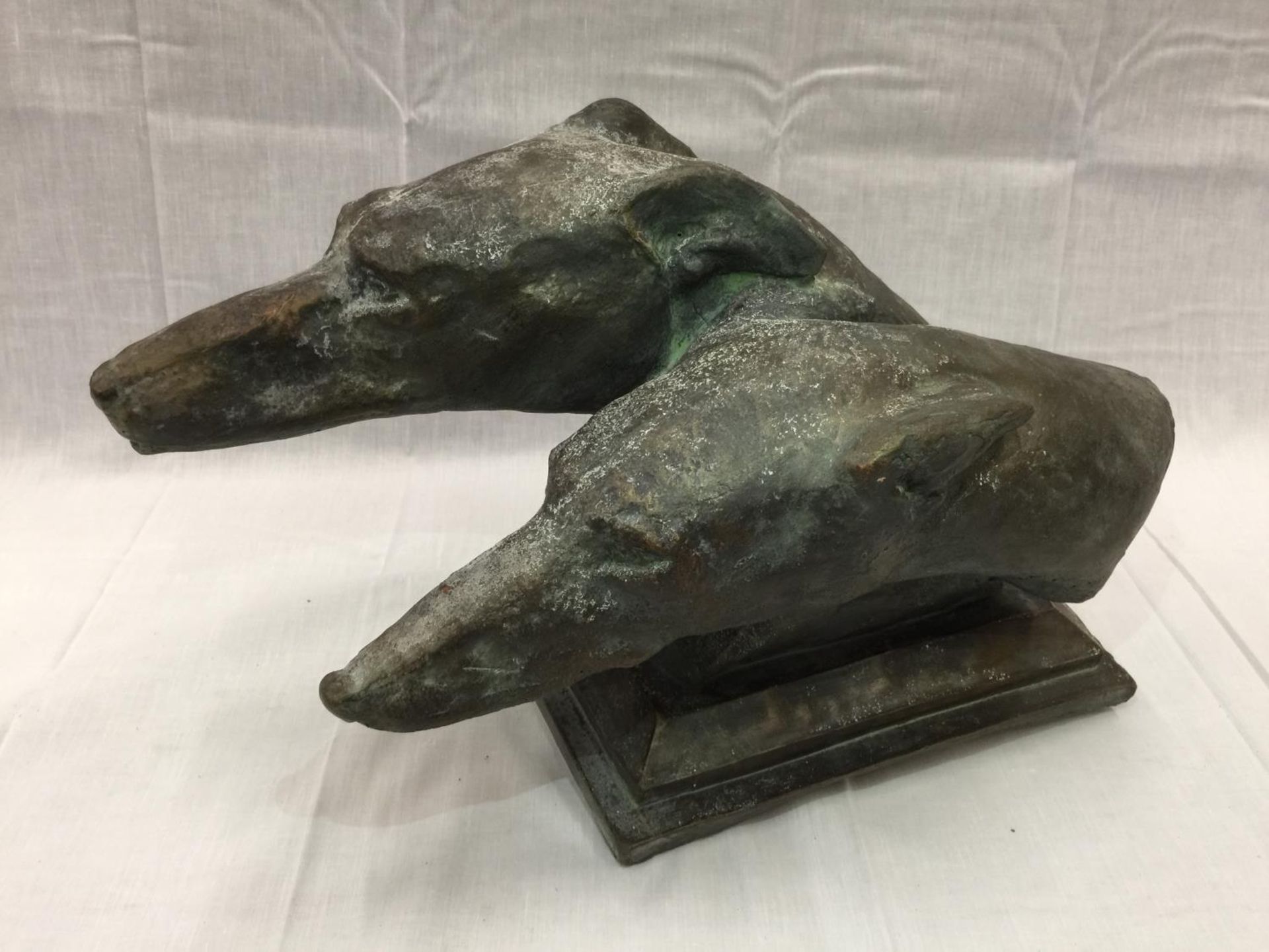 A BRONZE EFFECT STONE BUST OF TWO GREYHOUND HEADS LENGTH 48CM HEIGHT 29CM