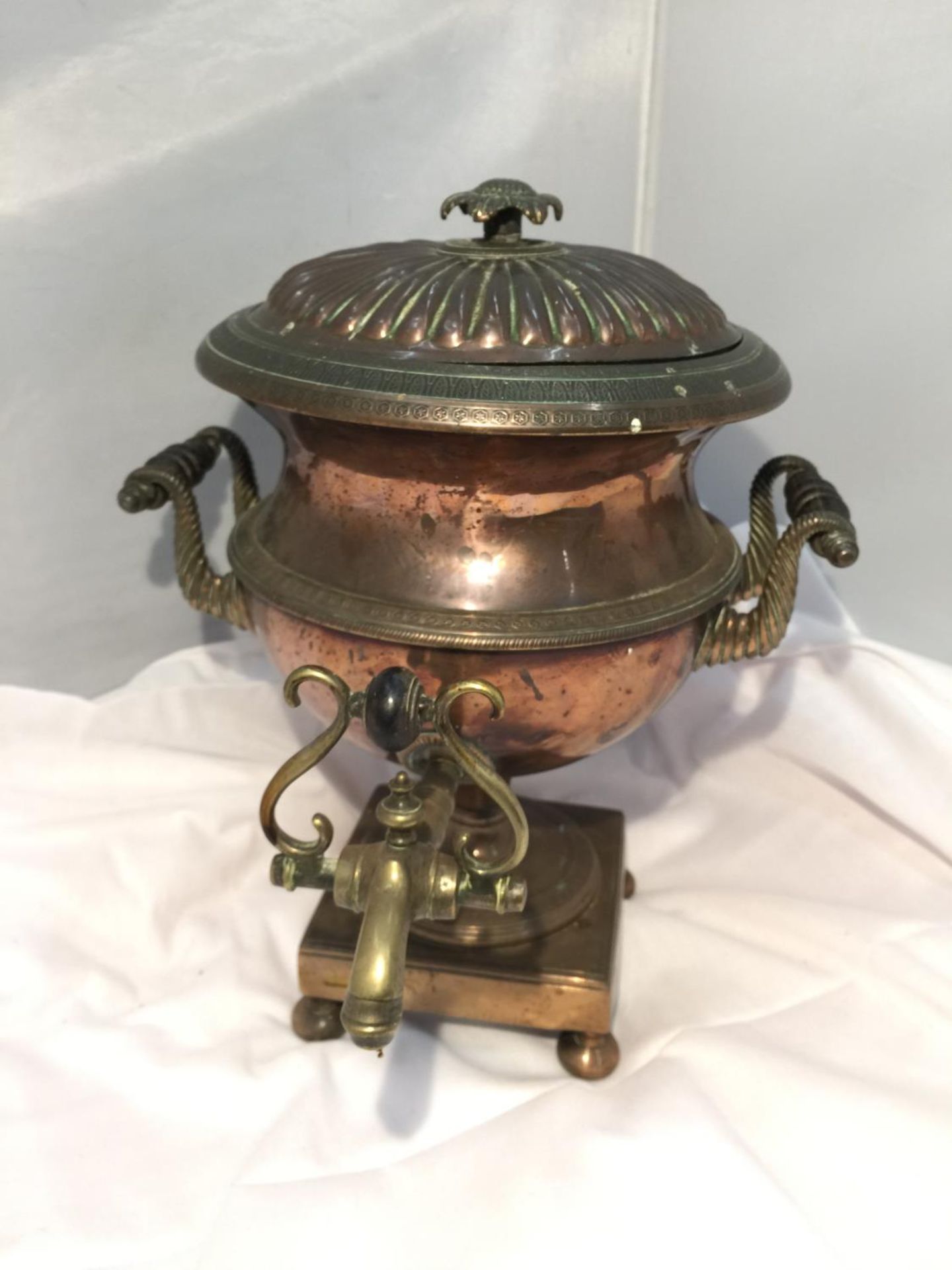 A VINTAGE BRASS AND COPPER TEA URN WITH TAP