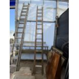 A VINTAGE WOODEN TWO SECTION EXTENDING LADDER (12 RUNGS PER SECTION)