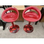 A PAIR OF BRIGHT RED PUMP ACTION STOOLS