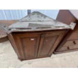 A GEORGE III OAK TWO DOOR CORNER CUPBOARD