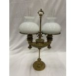 A VINTAGE BRASS TWIN OIL LAMP WITH GLASS FUNNELS AND MILK GLASS SHADES HEIGHT 66CM