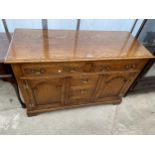 A GEORGE III STYLE LIGHT OAK DRESSER BASE ENCLOSING THREE SHORT AND TWO LONG DRAWERS AND TWO