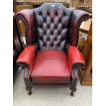 AN OXBLOOD WINGED FIRESIDE CHAIR ON CABRIOLE LEGS