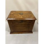 AN EARLY 20TH CENTURY OAK STATIONARY BOX WHICH OPENS TO A LEATHER WRITING DESK, SHIELD ON THE LID.