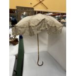 A VINTAGE CREAM LACE PARASOL WITH A WOODEN HANDLE