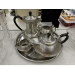 A HAND HAMMERED PEWTER TEA SERVICE ON A TRAY TO INCLUDE TEA AND COFFEE POT, CREAM JUG, SUGAR BOWL